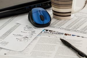 Tax paperwork and a newspaper on a desk