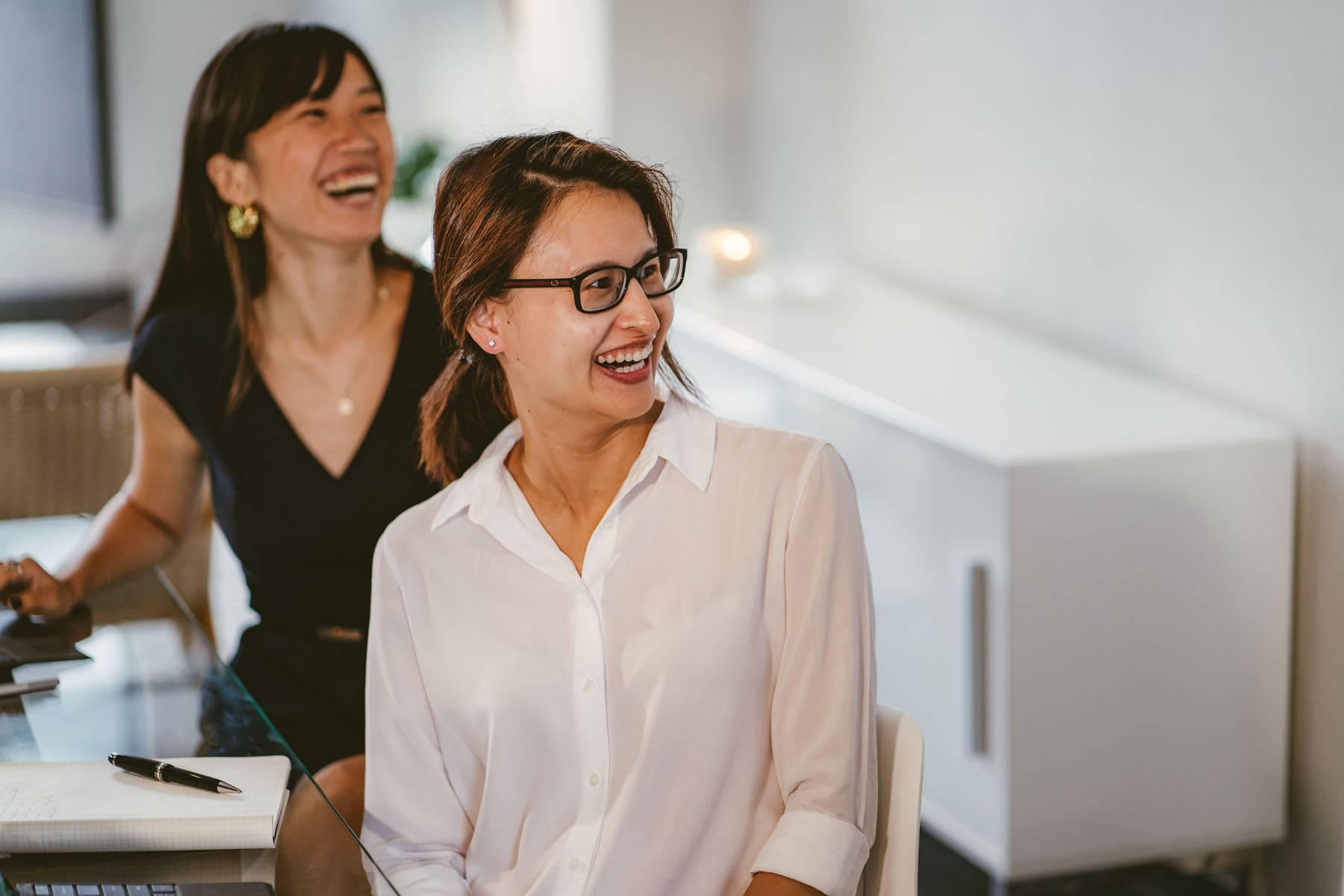 Two women laughing together during a client meeting at Prime Partners North Sydney office